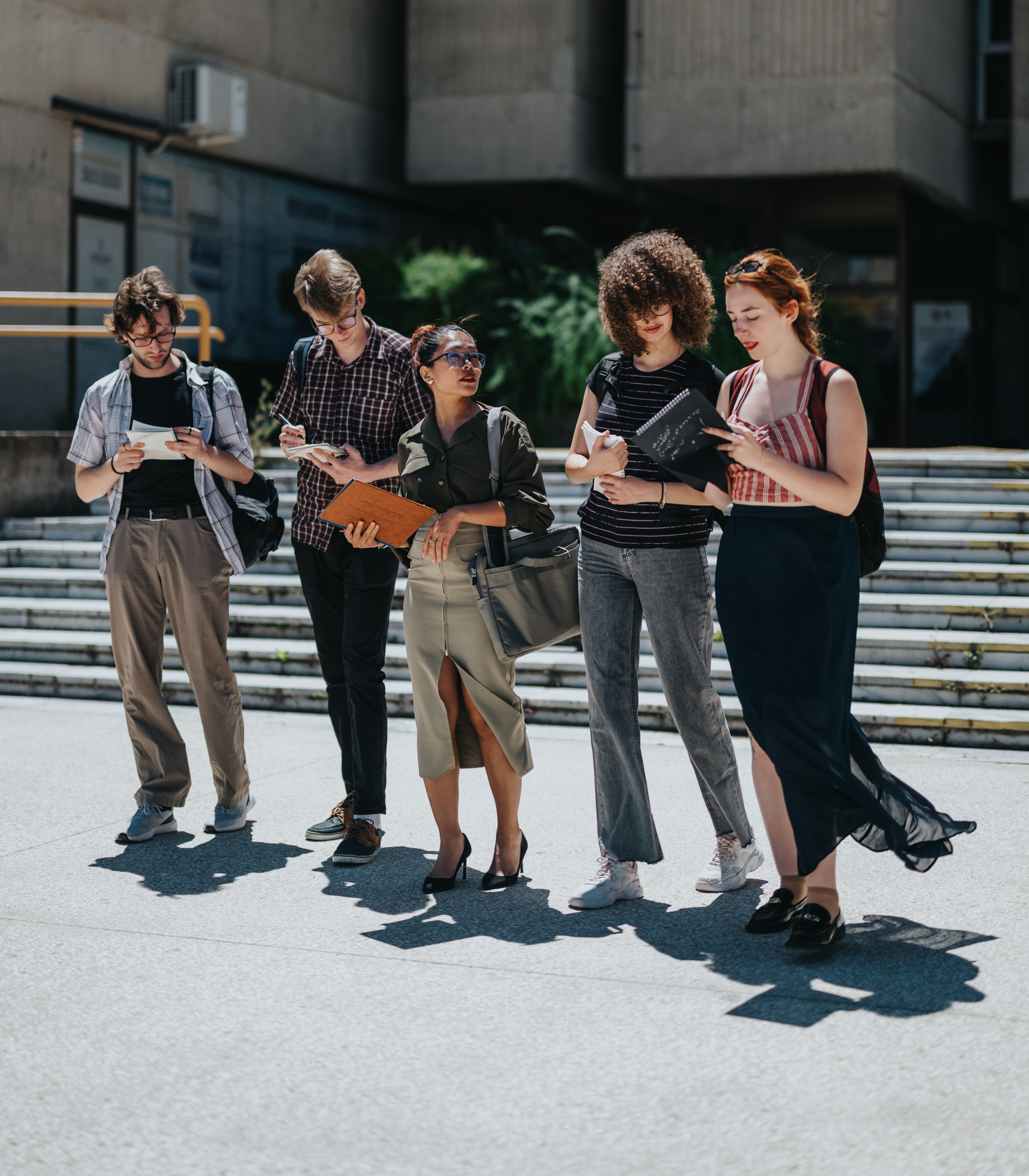 A group of 5 people standing together on a university campus